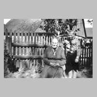 055-0002 Grossmutter Berta Glang mit Enkel  Rudi Glang. Hinter dem Zaun die Scheune von Glang.jpg